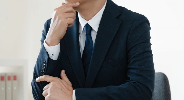顎に手を当てる男性